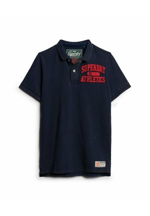 Polo de marina hecho de algodón, con cuello tipo camisa, mangas cortas, texto bordado en rojo "SUPERDRY 72 ATHLETICS" y una etiqueta en el dobladillo.