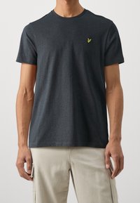 T-shirt a maniche corte grigio scuro in misto cotone, con scollatura rotonda e un piccolo logo verde ricamato sul lato sinistro del petto.