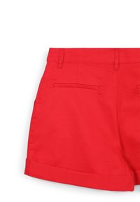 Shorts en coton rouge avec une taille ajustée, passants de ceinture et double poches arrière. Dotés de ourlets roulés et d'une texture lisse.