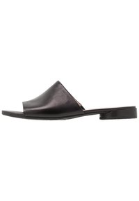Černé kožené sandály na klínku s minimalistickým designem, širším svrškem, otevřenou špičkou a nízkým plochým podpatkem. Hladká textura, bez zdobení.