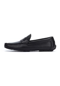 Mocasines de cuero negro con un diseño de perfil bajo y sin cordones, que cuentan con una puntera cosida y detalles texturizados en el empaque. Acentos de suela de goma.