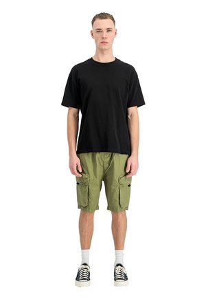 Young man standing straight wearing a black t-shirt, olive green cargo shorts, white socks, and black sneakers on a white background.