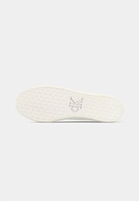 Hvit sneakersåle med teksturert, mønstret grep. Har en subtil logo i midten. Glatt overflate og avrundet tådesign.