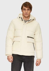 Daunenjacke inOff-White, ausgestattet mit Kapuze, zwei vorderen Taschen und dunklen Reißverschluss-Akzenten. Mit gestepptem Material für zusätzliche Wärme entworfen.