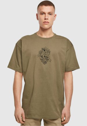 Oliven grønn bomulls T-skjorte med korte ermer, med et svart grafisk design av et hjerte omgitt av blomster og et bånd med tekst.