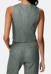 Grauer Leinen-Cropped-Top mit Rundhalsausschnitt und klaren Linien. Verfügt über einen Rücken-Schlitz und Taschen an der Taille des passenden Unterteils.