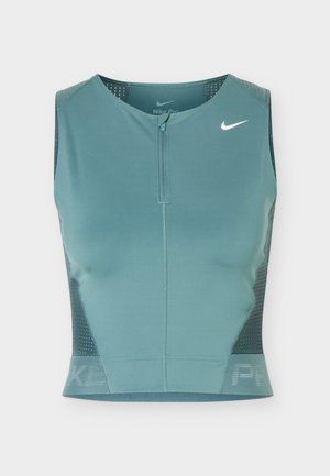 Sleeveless teal athletic crop top with front zipper, mesh side panels, and white Nike swoosh logo on the upper left chest.
