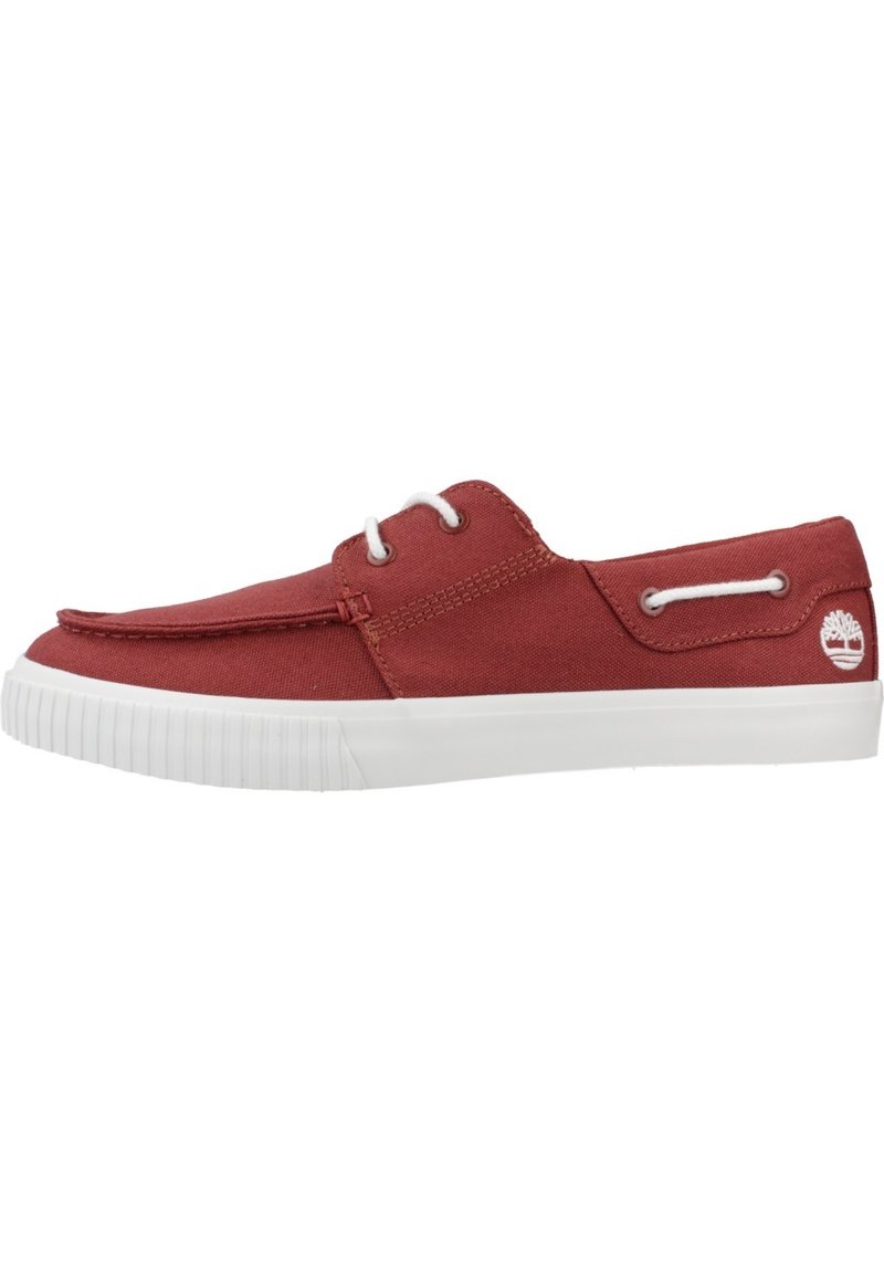 Zapatilla de lona roja con suela de goma blanca, diseño de cordones y acento de logo en el lateral. Textura suave y silueta sencilla.