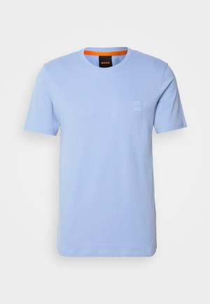 Light blue cotton T-shirt with short sleeves, round neckline, and a small embossed logo patch on the chest. Contrasting orange inner collar.