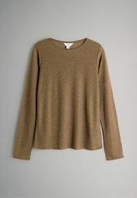 Rudas ilgarankovis megztinis su apvalia apykakle ir tiesiu hemu, rodomas prieš paprastą šviesiai pilką foną.