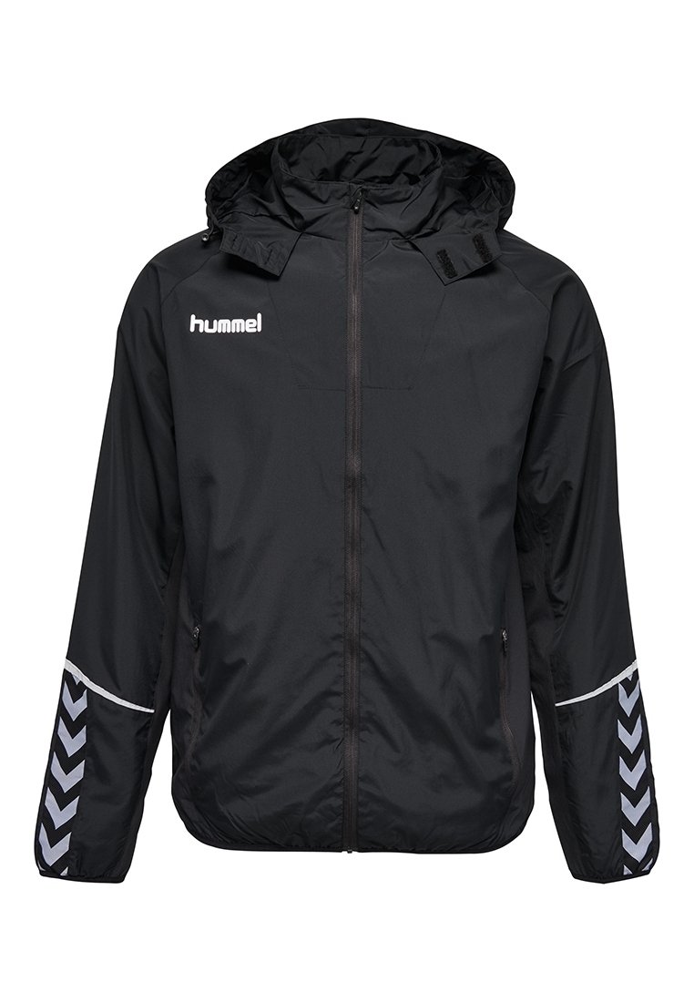 Veste de sport Hummel noire avec capuche, fermeture éclair à l'avant, poches latérales zippées et motif en chevron sur les manches inférieures.