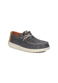Scarpa in tessuto grigio con finitura testurizzata, suola beige maculata e un accento in pelle marrone sul tallone. Presenta una costruzione leggera e lacci.