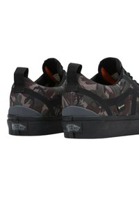 Vans sneakers med ett camouflagemönster i mörkgrått och olivgrönt, med svarta accenter, textilmaterial och gummisåler.