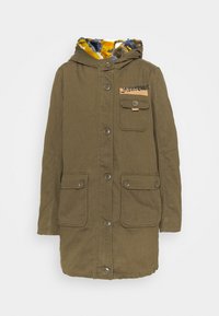 Chaqueta verde oliva con capucha forrada de piel, cierre de botones en el frente y dos bolsillos laterales. Cuenta con un bolsillo en el pecho con un parche de logo. Tejido texturizado.