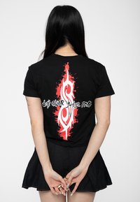 Black cotton t-shirt featuring a red graphic splatter design with white text "don't ever judge me" positioned on the back.