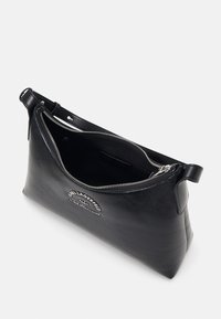 Sac à main en cuir noir avec une ouverture zippée, texture lisse, logo en relief et une seule poignée. L'intérieur est non doublé et spacieux.