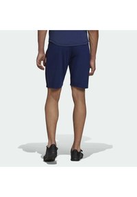 Pantaloni sportivi blu navy realizzati in tessuto leggero, con una vestibilità comoda e strisce laterali. Indossati con scarpe da ginnastica nere.
