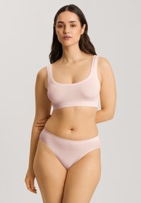 Ljusrosa bralette med breda axelremmar, rund urringning och matchande högmidjade trosor. Slät, stretchig tyg med minimala sömmar.