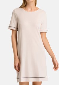 Abito corto beige chiaro a maniche corte con scollo rotondo, rifiniture nere su maniche e orlo, realizzato in tessuto morbido e liscio. Lunghezza sopra il ginocchio.