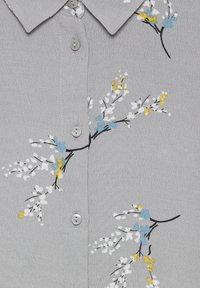Grijs overhemd met kraag en bloemenborduurwerk in wit, blauw en geel. Voorzien van knopen aan de voorkant en een textiel met een subtiele glans.