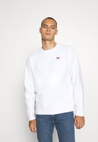 Witte sweatshirts met ronde hals van een katoenmix, voorzien van een klein rood Levi's-logo op de linkerkant van de borst, gecombineerd met blauwe spijkerbroek.