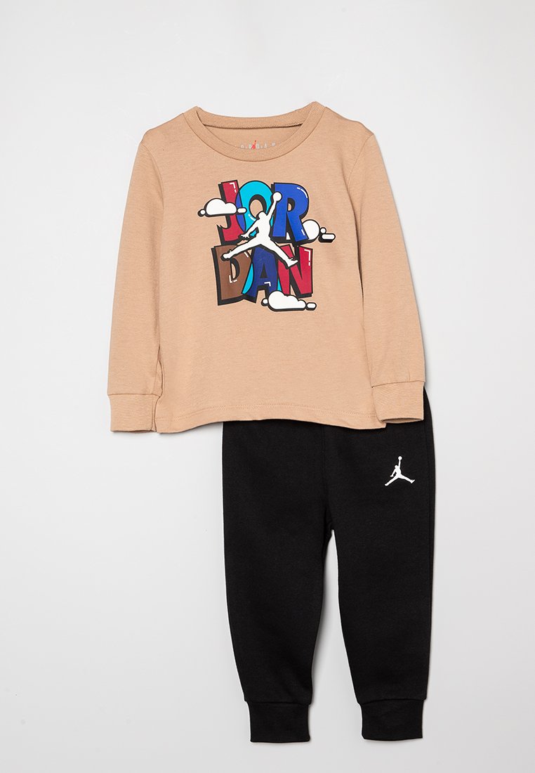 Maglietta beige a maniche lunghe con grafica colorata "JORDAN" e pantaloni felpati neri con logo bianco. Tessuto morbido, vestibilità casual, polsini a coste.