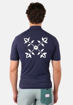 T-shirt de bain à manches courtes bleu marine avec un motif floral blanc au dos. Fabriqué en matériau extensible, design ajusté et col canalé.