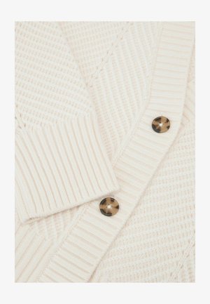Lys beige tekstureret cardigan med ribstrikkede sektioner, v-udskæring og to mørke skildpaddeskalsknapper foran.