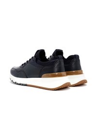 Marine leren sneakers met een witte tussenzool en een bruine buitenzool. Voorzien van gestructureerde details en vetersluiting. Geschikt voor casual draagstijl.