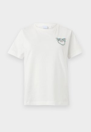 Bela bombažna majica s kratkimi rokavi in okroglo ovratnikom. Ima okrasno modro in srebrno obdelavo v obliki srca.