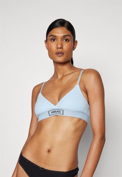 Vaaleansininen ribbikuvioinen bralette, jossa on V-kaula-aukko. Varusteena ohuet säädettävät olkaimet ja musta Versace-logo vyötärönauhan kohdalla. Tasainen tekstuuri.
