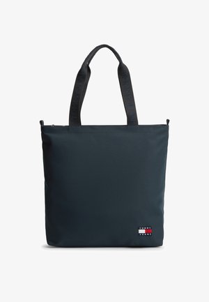 Prostokątna torba na ramię w ciemnoniebieskim kolorze z czarnymi, firmowymi uchwytami oraz naszywką z logo Tommy Jeans w dolnym prawym rogu.
