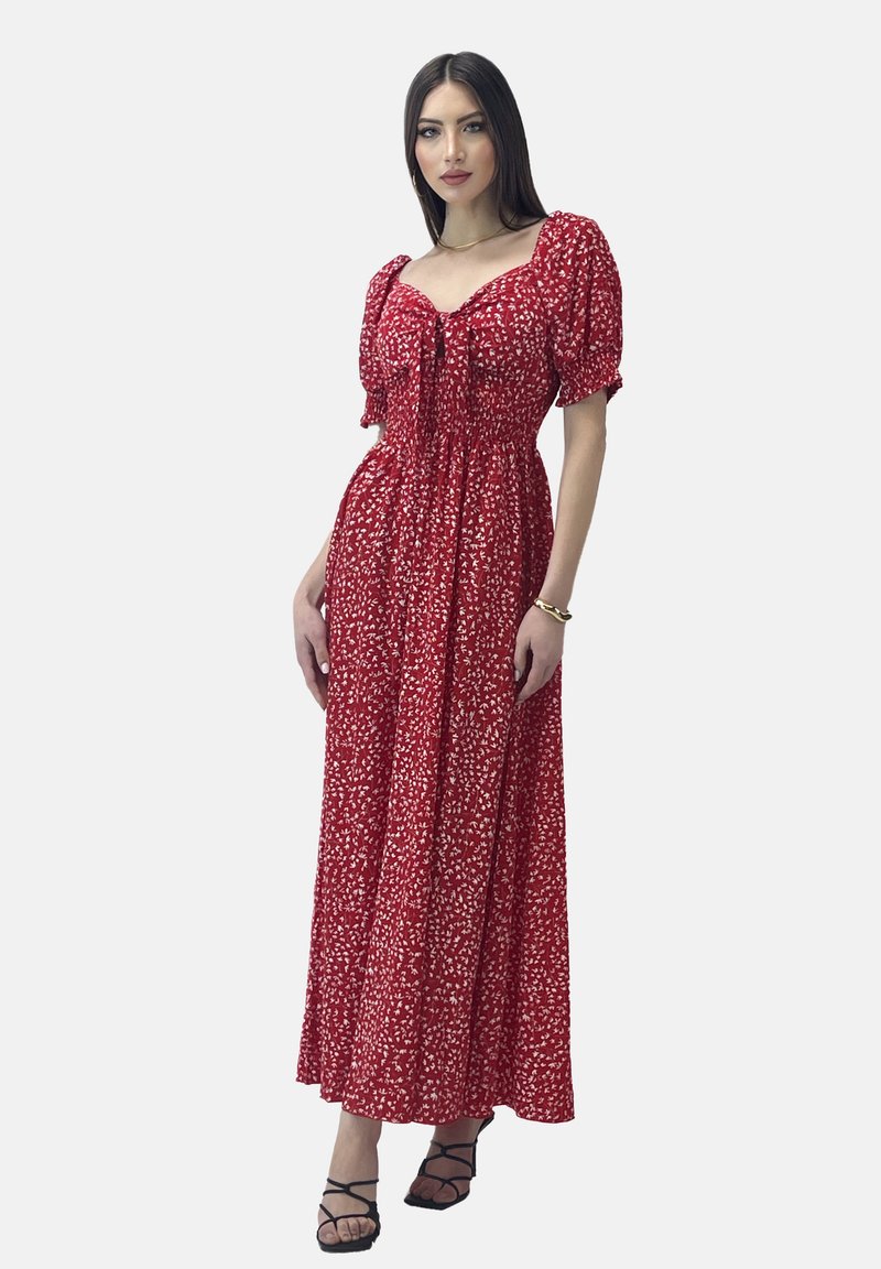 Röd blommig maxiklänning med puffärmar och knytning i halsen; har en smockad byst och en flödande kjol med en subtil textur.