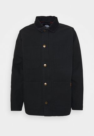 Giacca nera in canvas con colletto in corduroy, due tasche frontali e bottoni in ottone. Linee pulite e design a taglio dritto.