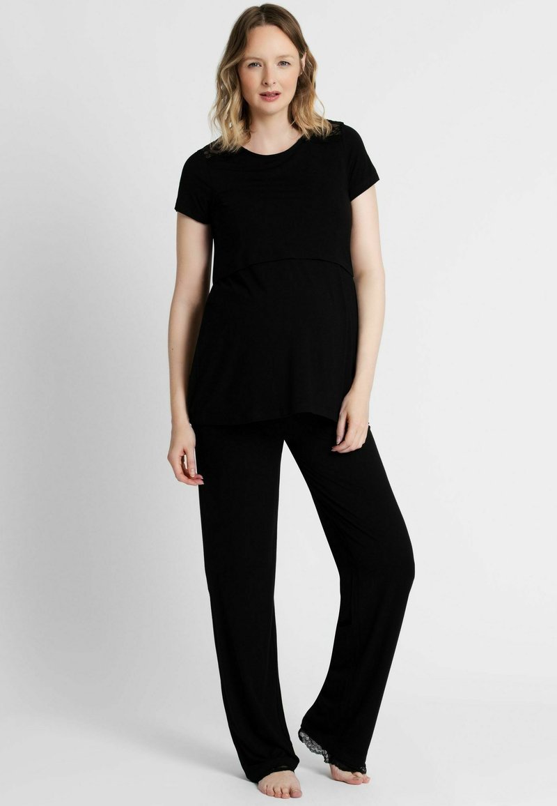 Čierny tehotenský loungewear set s krátkym rukávom a zakriveným lemom, ktorý obsahuje aj nohavice s čipkovým detailom na členku. Mäkká tkanina.