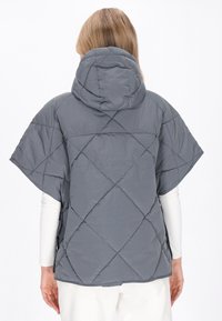 Poncho căptușit gri cu glugă, cu mâneci ample și croială lejeră. Prezintă un model de cusături în diamant și o textură de țesătură netedă și lucioasă.