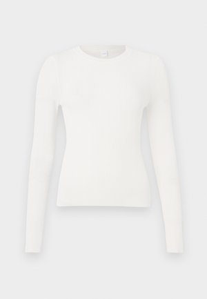 Hvit ribbestrikket topp med lange ermer, rund hals og tettsittende design. Stoffet ser mykt ut med en subtil tekstur og uten synlige detaljer.