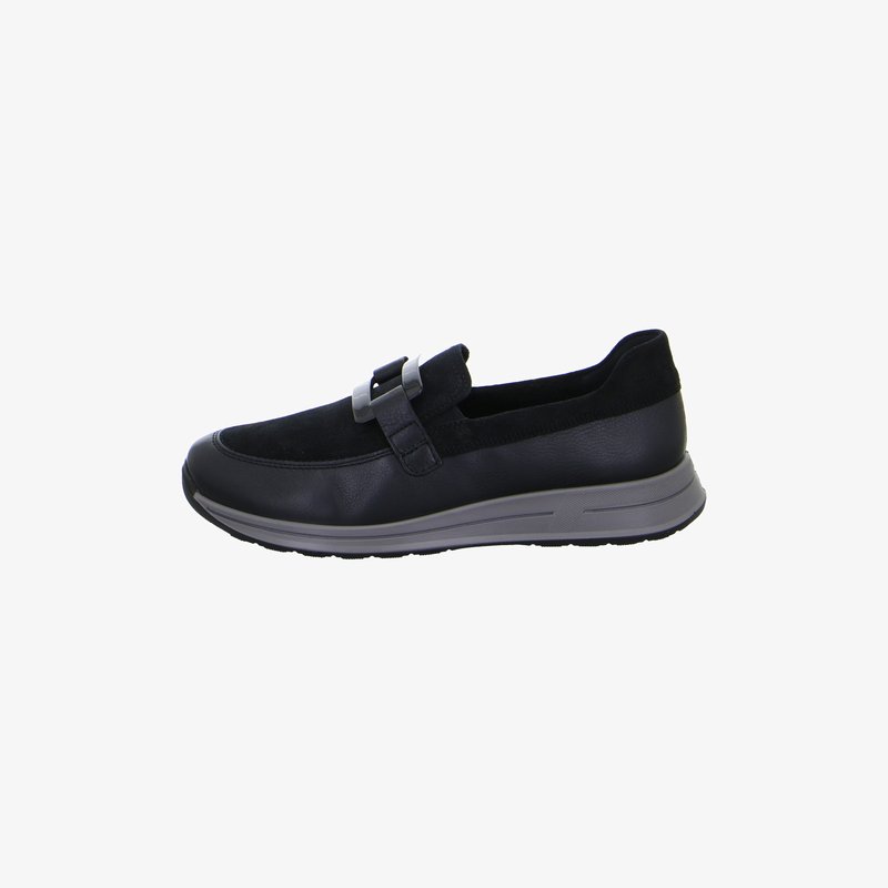 Black slip-on shoe with suede upper, leather accents, gray rubber sole, and decorative buckle across the top, side view.
