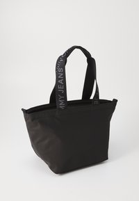 Schwarze Tote-Tasche mit strukturierter Form, aus glattem Stoff gefertigt. Verfügt über zwei weiche Tragegriffe mit dem in Grau eingewebten Text "MY JEANS".