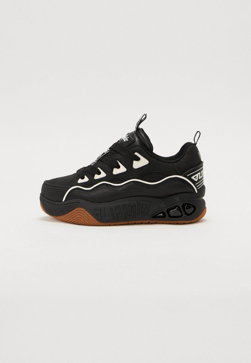 Black sneakers with a chunky design, featuring white accents, textured rubber sole, and a distinctive logo on the side.