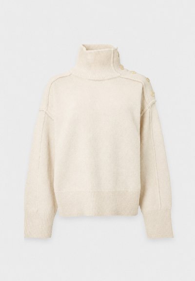 Pull à col roulé en maille couleur crème avec manches longues et boutons décoratifs le long de la couture de l'épaule gauche.