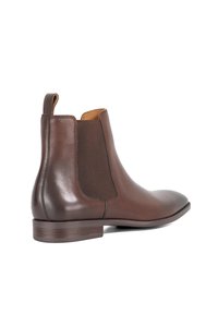 Bottine Chelsea en cuir marron avec panneau latéral élastique, tirant à l'arrière, talon bas empilé et embout arrondi, vue de l'extérieur.