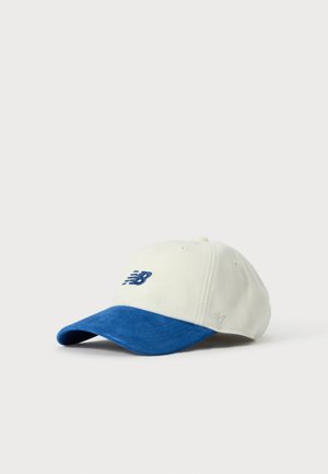 Hvid og blå baseballcap med New Balance-logo broderet foran, sat mod en ensartet lys baggrund.