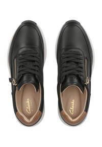 Schwarze Ledersneaker mit glatter Oberfläche, die ein goldenes Reißverschlussdetail an der Seite und einen kontrastierenden braunen Akzent an der Ferse aufweisen.