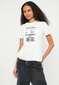 Λευκό κοντομάνικο μπλουζάκι με γραφικό σχέδιο που περιλαμβάνει έντονο μαύρο κείμενο. Απαλό βαμβακερό υλικό, άνετη εφαρμογή, στρογγυλή λαιμόκοψη.