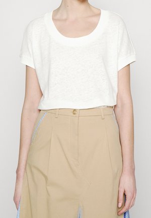 Biały t-shirt z krótkim rękawem i szerokim dekoltem, wykonany z fakturowanej tkaniny, w połączeniu z beżowymi spodniami z wysokim stanem i bocznymi paskami.