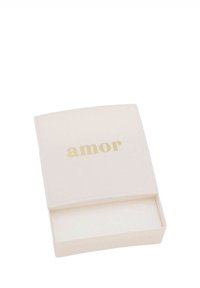 Liten vit rektangulär låda med avtagbart lock, guldtexten "amor" ovanpå och tom insida.