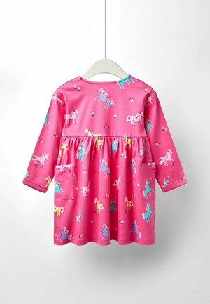 Abito lungo a maniche lunghe di colore rosa con una fantasia di unicorni fantasiosa, vita arricciata e due tasche frontali. Tessuto morbido con accenti arcobaleno e floreali.