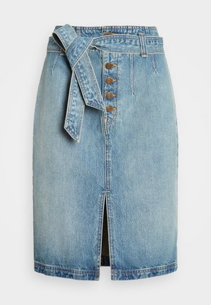 Jeanskjol i ljusblått med midjeband, knäppning fram och en mittslits. Har en rak skärning och subtil blekning.