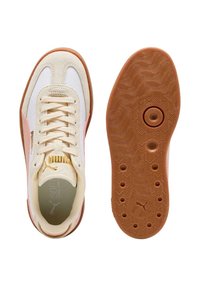 Scarpe sportive cream e rosa con una parte superiore testurizzata, chiusura con lacci e suola in gomma marrone caratterizzata da motivi circolari e ondulati.